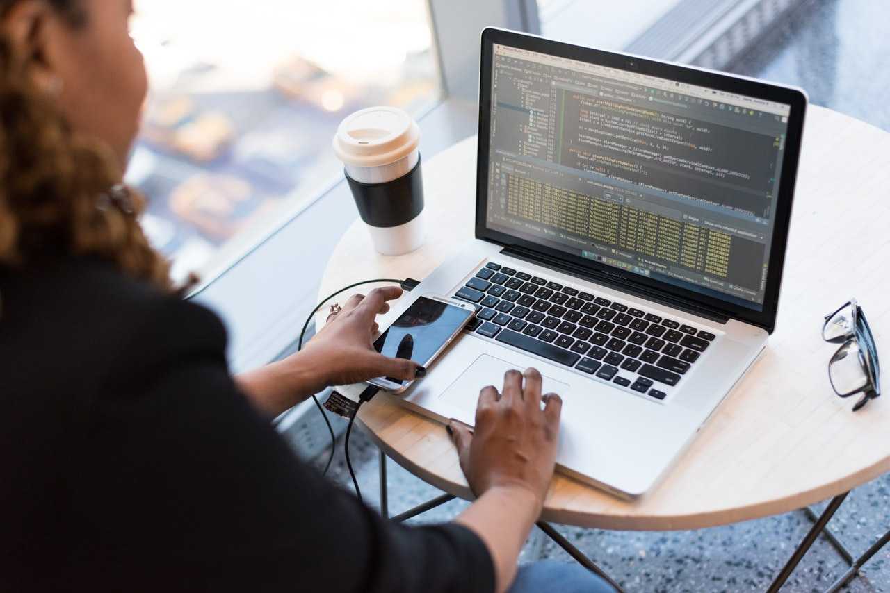 Woman looking at her laptop and phone